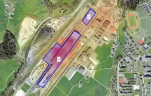 An aerial view of an industrial area, segmented into zones with numbered labels and highlighted with a thermal overlay indicating land surface temperature variations. Two distinct zones are outlined in blue, with Zone 0 showing a higher temperature.