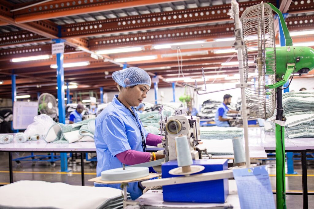 Woman sews fabric at a textile factory.