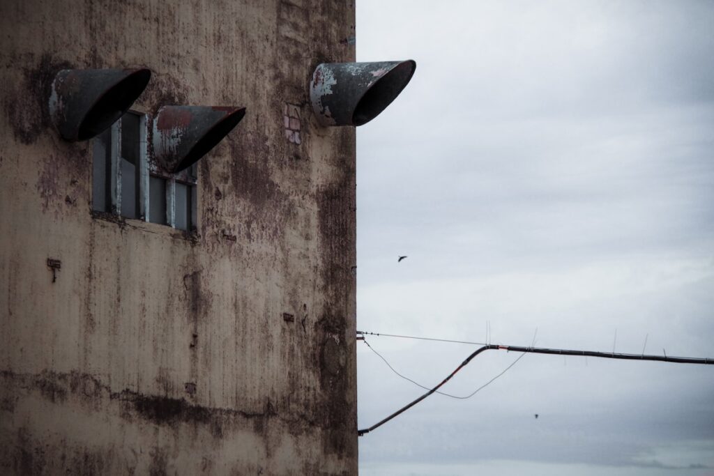 a rusted building with three round windows
