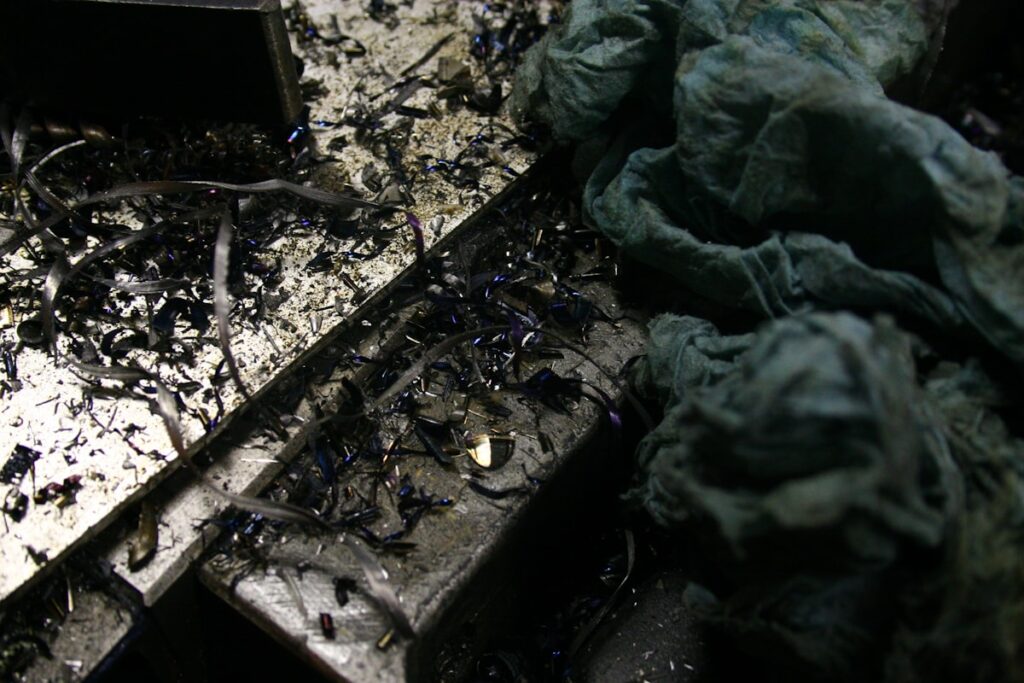Scattered debris and crumpled fabric on a dark surface.