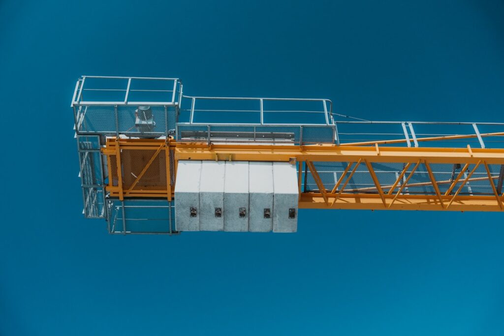 Yellow construction crane against a clear blue sky