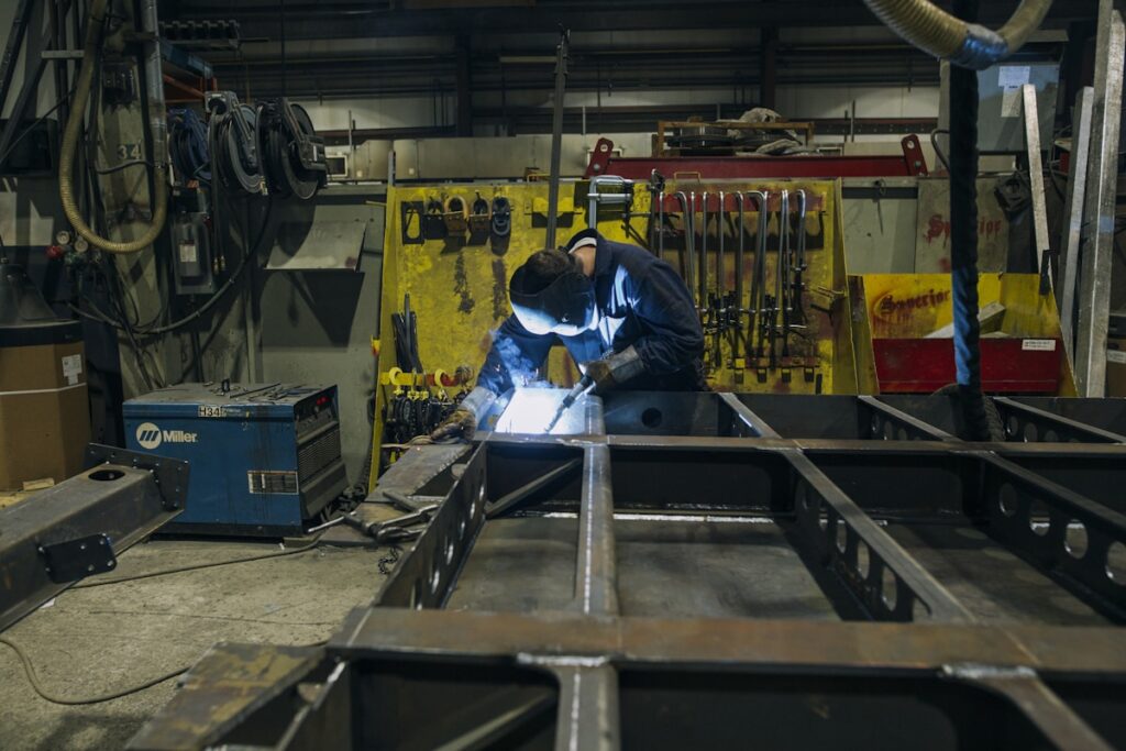 a man in a factory working on a piece of metal