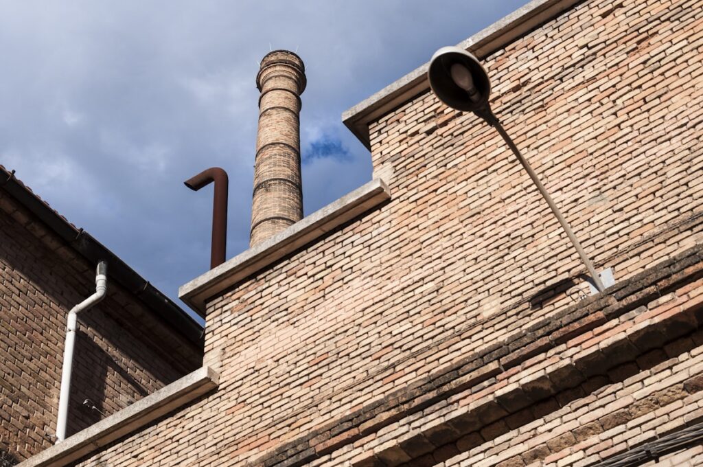 a brick building with a pipe sticking out of it's side