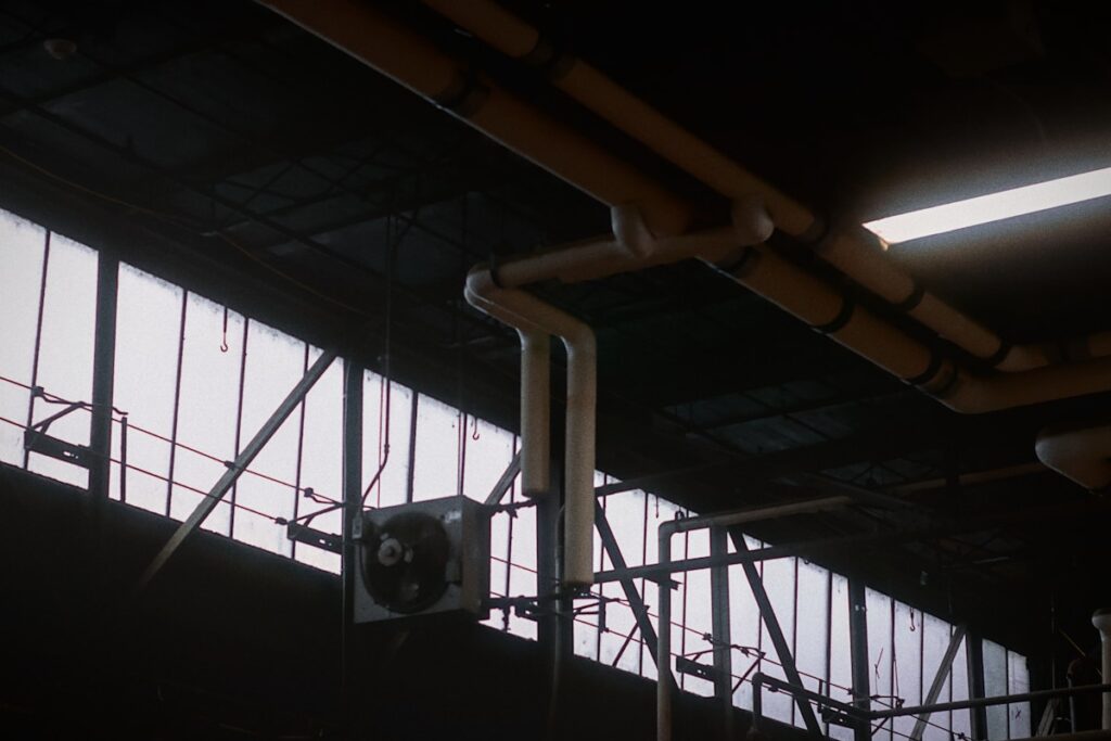 an industrial building with pipes and a clock