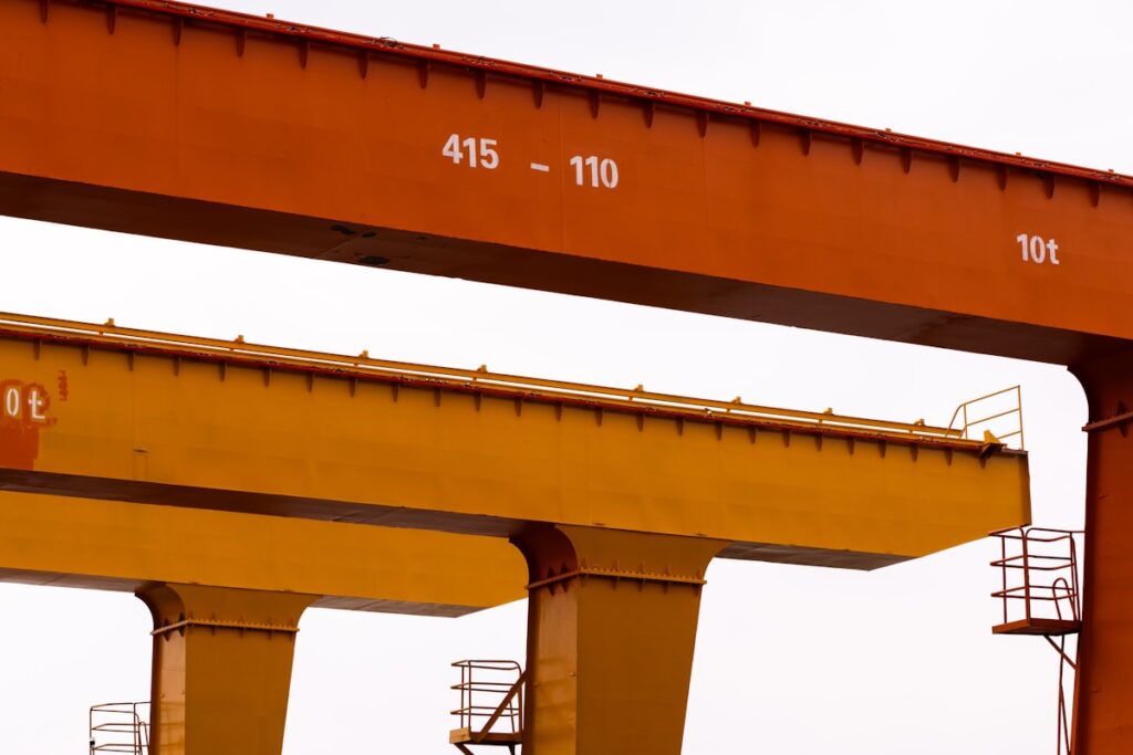 Two large industrial cranes against a white sky