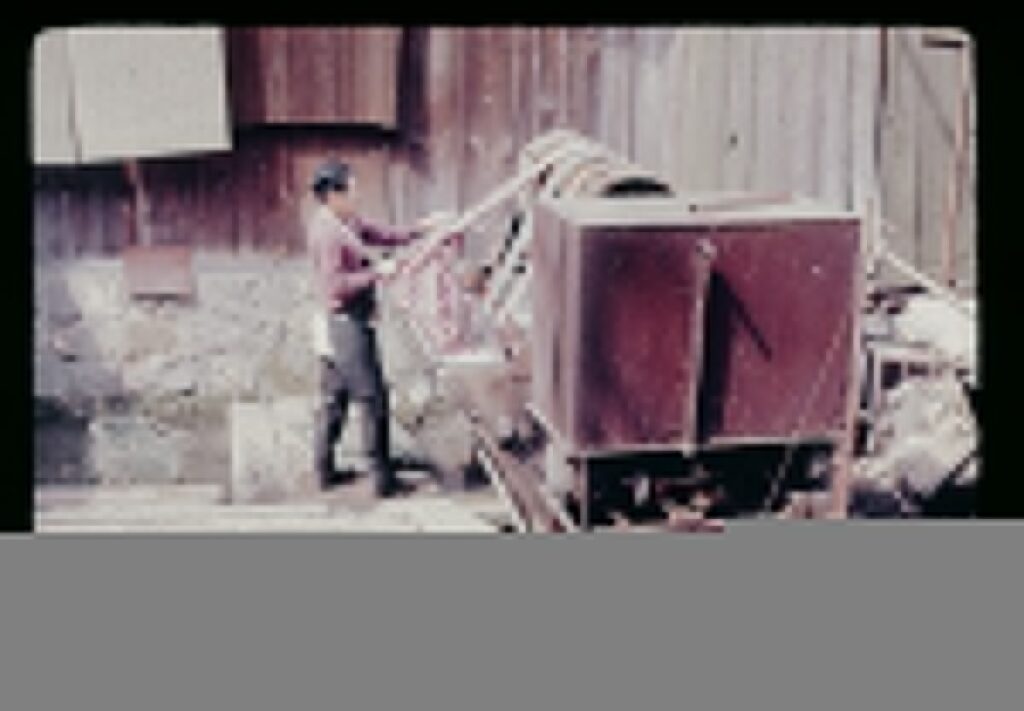 A man standing next to a pile of junk